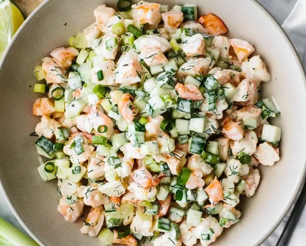 Delicious cucumber shrimp salad served in a bowl with vibrant vegetables.