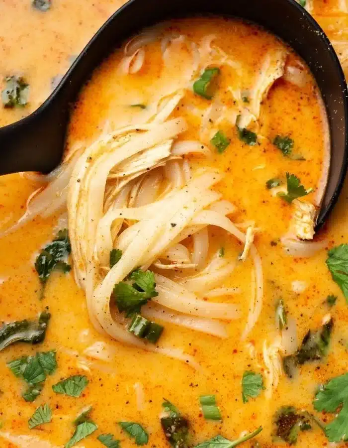 Bowl of easy Thai chicken soup garnished with herbs and lime