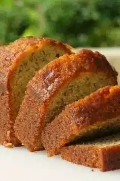 Deliciously moist banana bread fresh out of the oven on a wooden table.
