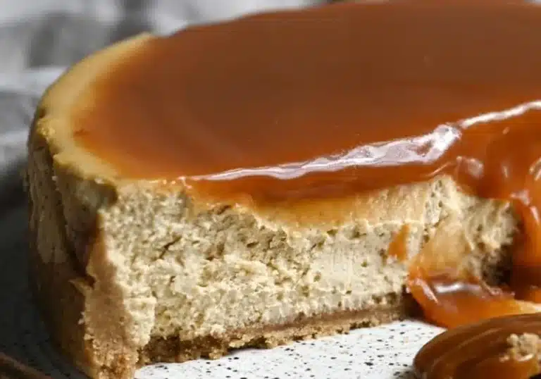 Slice of Apple Cider Cheesecake topped with caramel and cinnamon