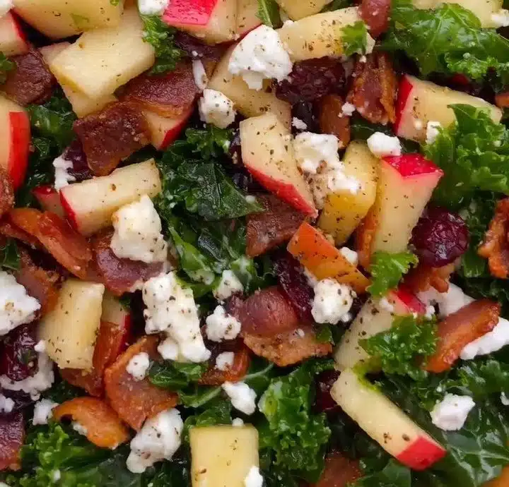 Fresh Apple Cranberry Bacon Kale Salad topped with nuts