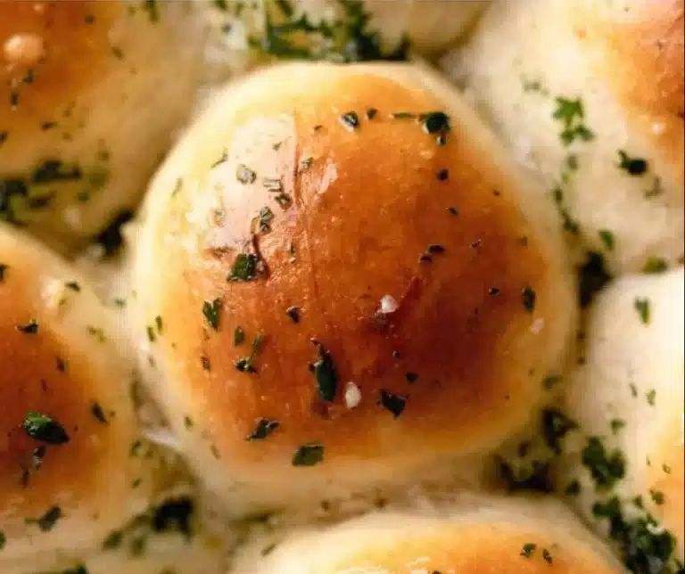 Freshly baked garlic butter bread rolls on a wooden serving board
