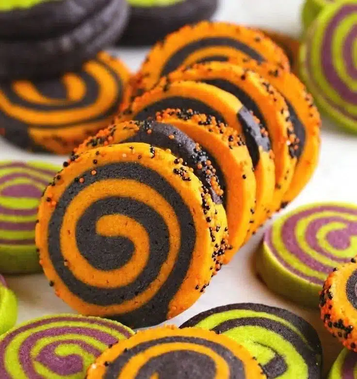 Plate of colorful Halloween pinwheel sugar cookies with festive decorations