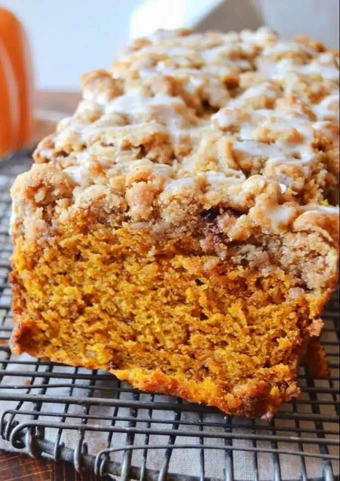 Loaf of Pumpkin Apple Bread topped with streusel on a wooden table