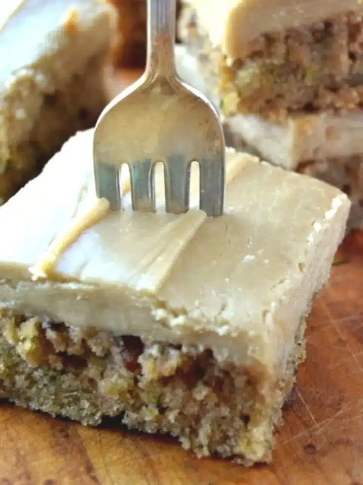 Zucchini pecan bars fresh out of the oven, topped with nuts and drizzled with icing.